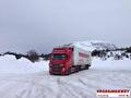 Vrachtwagen van Vroegindewey op een besneeuwde weg in Scandinavië